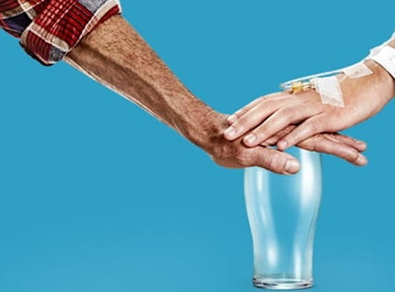 Dry Feb Two people placing their hands on an empty alcohol glass.