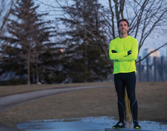 Nick, un survivant de cancer métastatique, debout à l’extérieur, les bras croisés