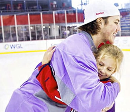 Un joueur de hockey étreignant une jeune sympathisante.