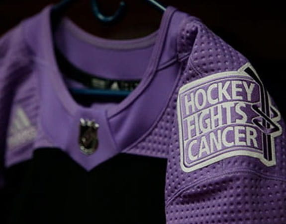 La photo d’un chandail lilas avec l’écusson de Hockey Fights Cancer.