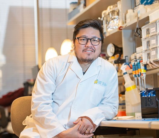 Dr. Chan leaning on a counter top