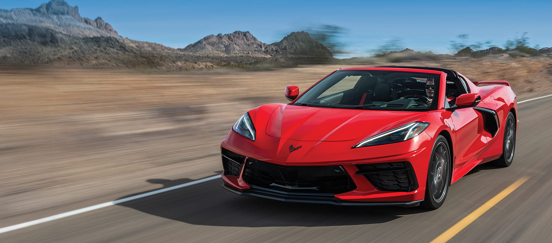 A 2026 Chevrolet Corvette Stingray on a road with a scenic background