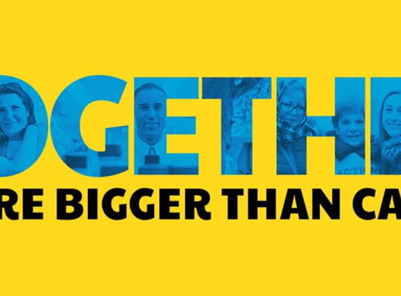 A yellow banner with the words "Together we are bigger than cancer"