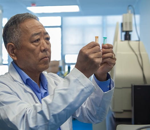 Un chercheur comparant des fioles dans un laboratoire 
