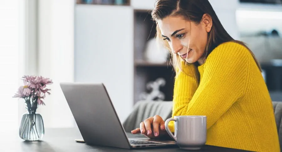 A women sitting at a table with her laptop