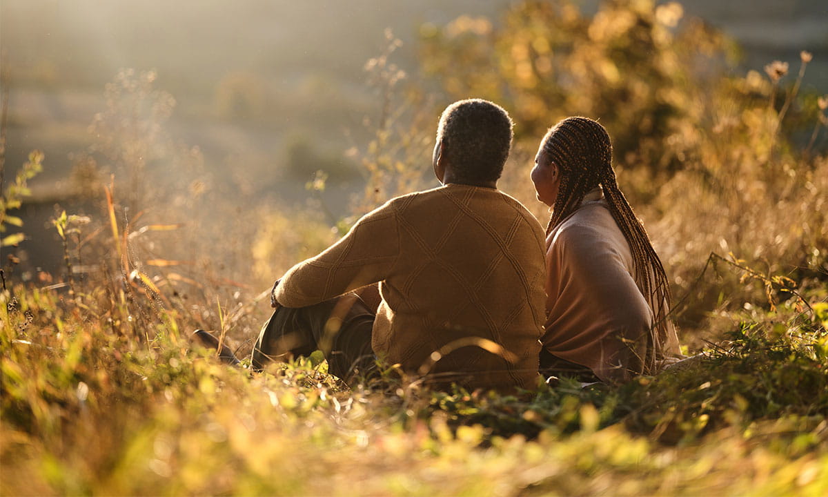 Elderly couple looking at the horizon during a sunset. 
