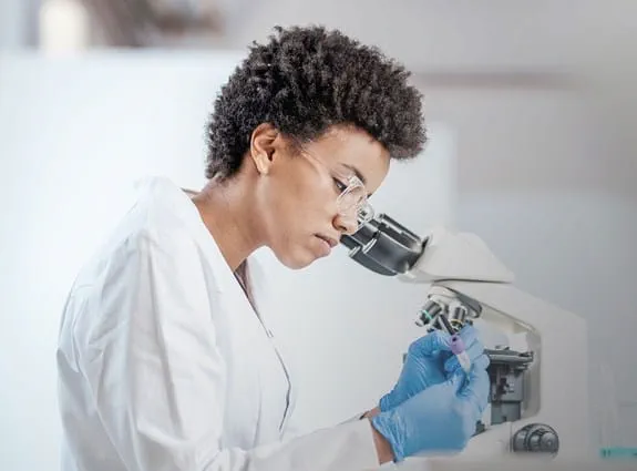 Woman looks through a microscope