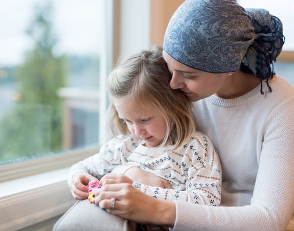 Mother and child sitting and playing by a window