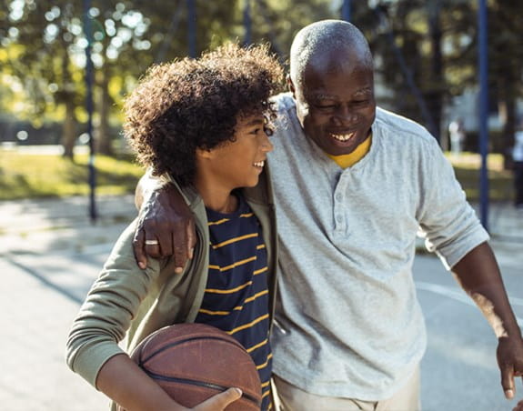 Un grand-père et son petit-fils marchant ensemble avec un ballon de basket